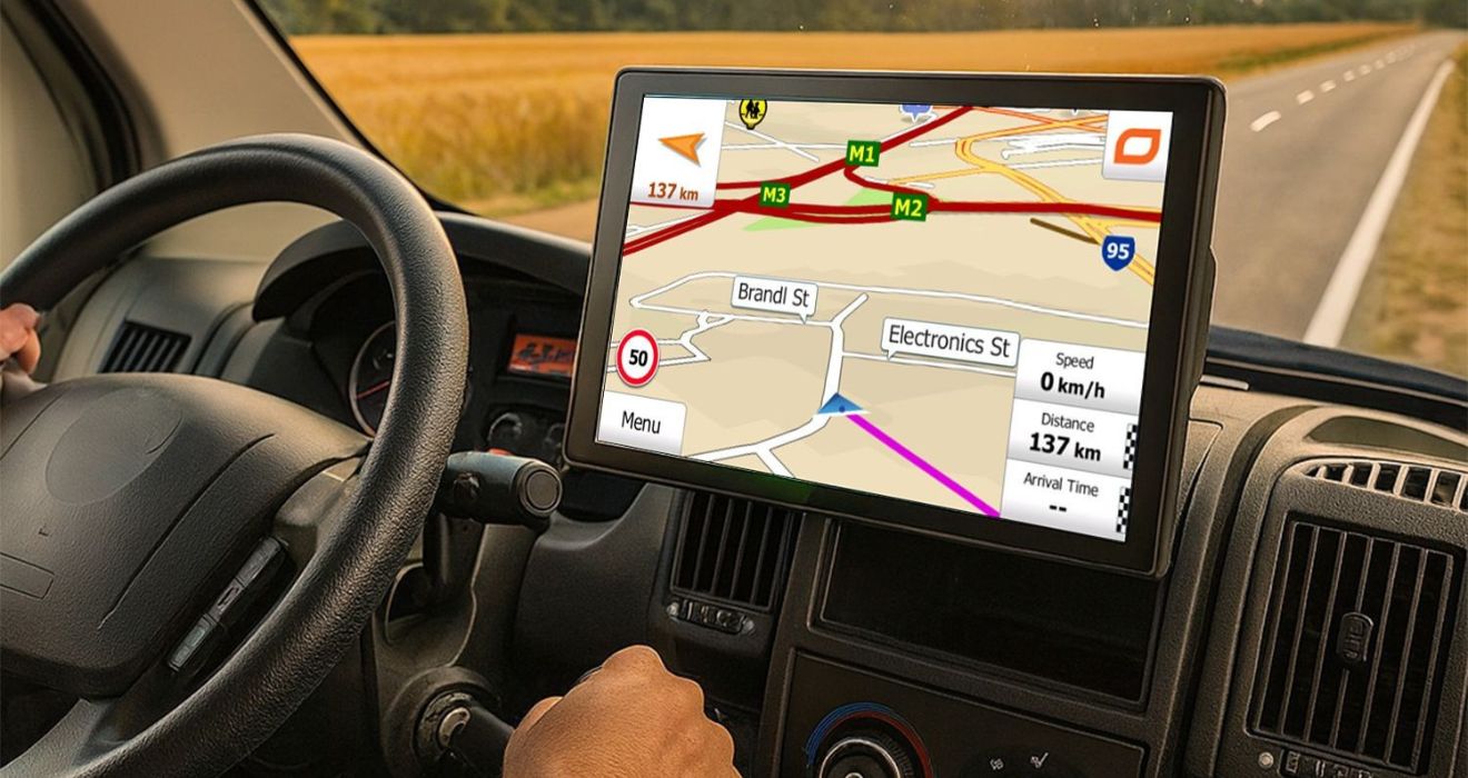 LKW-Navigationsgerät im Cockpit eines Trucks bei Sonnenuntergang – speziell für Lkw-Routen, Mautvermeidung und sicheres Fahren auf Fernstrecken